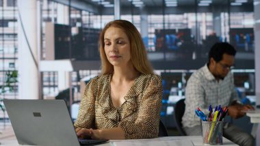 Şirket masasında oturan kendine güvenen yetenekli girişimci, iş büyümesini tahmin etmek için dizüstü bilgisayarını kullanıyor. Finansal planlamayı yönetmek ve hedeflere ulaşmak. Kamera A.