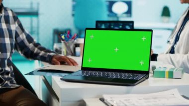 Pratisyen kadın ve hasta laptopta yeşil ekrana bakıyor, kontrol sırasında ilaç ve ilaç öneriyor. Hintliler teşhis raporunu ve iyileşmeyi tartışıyor. Kamera A.