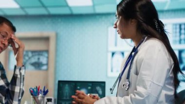 Hintli doktor hasta bir adam için ilaç ve ilaç sağlıyor ağrı kesiciler ve ilavelerle ağrıyı dindiriyor. Pratisyen hekim, tedaviyle kolayca iyileşmesini sağlıyor. Kamera A.