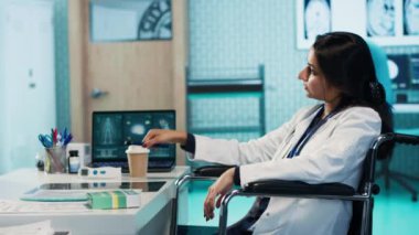 Engelli bir Hintli kadın doktor hastasına danışmanlık yapıyor, hastanede tedavi ve iyileşme planı öneriyor. Genç bir adamla pratisyen hekim toplantısı. Kamera A.
