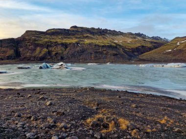 Diamond shaped Vatnajokull ice chunks floating on frozen lake in Iceland forming massive glacier lagoon, natural covered frost icy blocks. Icelandic rocks in wintry weather. clipart