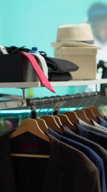 Dikey Video Moda perakende mağazasında bir mağazada ünlü bir tasarımcının çeşitli şık mevsimlik kıyafetleri sergileniyor, müşterileri şık seçenekleri keşfetmeye ve gardıroplarını yükseltmeye davet ediyor..
