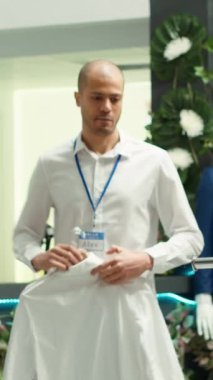 Dikey Video Ortadoğu mağazası çalışanı modern perakende mağazalarında kıyafet düzenliyor, moda tasarımcısından yeni koleksiyon için yer açıyor. Kaliteli bir alışveriş ortamı sağlıyorum. Kamera A.