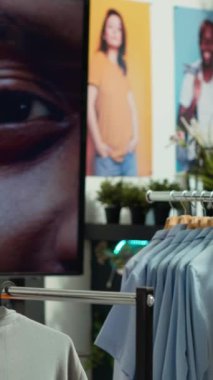 Dikey Videolu Asyalı kadın mağaza çalışanı askılarda yeni tasarımcı kıyafetleri düzenliyor, şık ve organize bir moda gösterisi yaratarak moda kıyafetlerinin yeni koleksiyonunu geliştiriyor. Kamera A.