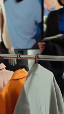 Dikey Video Moda butik işçisi mağazadaki askılarla ilgili her iki parçayı ayırarak yeni koleksiyonla şık bir moda gösterisi hazırlıyor. Tasarımcıyı ayarlamak, ürünleri üretmek. Kamera A.