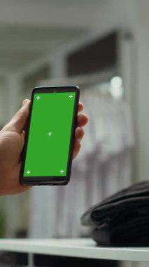Dikey Video Orta Doğulu adam yeşil ekran kullanıyor ve bir giyim mağazasında aksesuar düzenliyor, müşteriler için kemer ve kravatları ayırıyor. Perakende asistanı moda ilhamı veriyor.