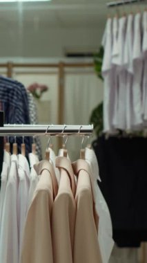 Dikey Video Moda rafları bir alışveriş merkezinde çeşitli şık moda ürünlerini sergiliyor, şık bir alışveriş deneyimi sunuyor ve modern modaya uygun parçalar seçiyor.