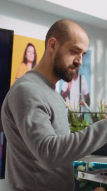 Alışveriş merkezindeki dikey video mağazası çalışanı alışverişçiye moda tavsiyesi veriyor, kişisel stil rehberliğini vurguluyor ve modern bir butikte perakende alışveriş deneyimini geliştiriyor. Kamera B.