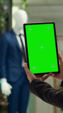 Tablette izole edilmiş fotokopi alanı gösteren dikey video mağazası çalışanı, müşteriler ve perakende terapi için yeni koleksiyon ürünlerini hazırlıyor. Moda kişisel ilhamı