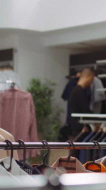 Dikey Video Moda butik işçisi mağazadaki askılarla ilgili her iki parçayı ayırarak yeni koleksiyonla şık bir moda gösterisi hazırlıyor. Tasarımcıyı ayarlamak, ürünleri üretmek. Kamera B.