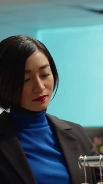 Dikey Video Tarzı kadın, modaya uygun kıyafetler ve canlı vitrinlerle çevrili modern bir butikte giyim seçeneklerini araştırıyor. Moda, tüketim ve perakende terapi gösteren Asyalı bir müşteri
