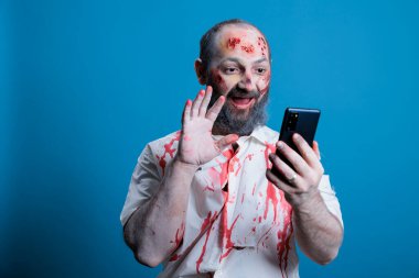 Korku filmi zombisi kılığındaki aktör portresi. Makyajlı, ara arasında video çağrısında konuşan. Telefonda telekonferans toplantısında ölümsüz bir canavar gibi giyinmiş bir adam, stüdyo geçmişi...