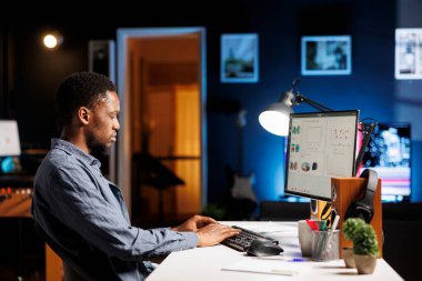 Ticari ilerleme şemalarına bakan ticaret mühendisi, karını artırmak ve hissedarlardan fon almak için evden çalışıyor. Uzman iş istatistiklerini çevrimiçi olarak değerlendirir.