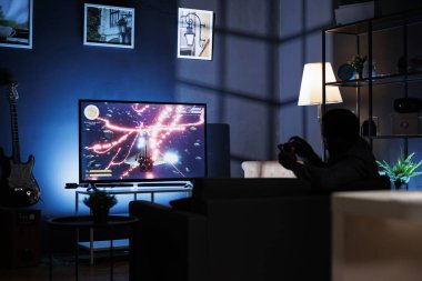 Adam TV 'de çok oyunculu video oyunları oynuyor, konsolunu oturma odasına kuruyor ve geceleri oyun oynuyor. Birinci şahıs nişancı yarışmasında mücadele eden oyuncu.