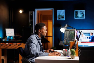 Video düzenleyici evde film montajı üzerinde görsel efektler yaratıyor, renk düzeltmesi üzerinde çalışıyor ve görüntü ve çerçeveleri düzenlemek için not veriyor. Freelancer dijital düzenleyici bilgisayar yazılımındaki klipleri düzenliyor.