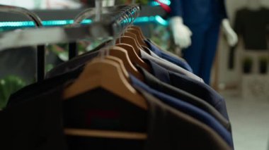 Alışveriş merkezindeki bir perakende mağazasında gündelik ve resmi kıyafet ürünleri sergilemek, müşterileri yeni bir tasarımcı koleksiyonunu keşfetmeye davet etmek. Askılarda moda esasları.