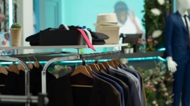 Mağazadaki ünlü bir tasarımcıdan şık mevsimlik giysiler sergileyen moda perakende mağazası müşterileri şık seçenekleri keşfetmeye ve gardıroplarını yükseltmeye davet ediyor..