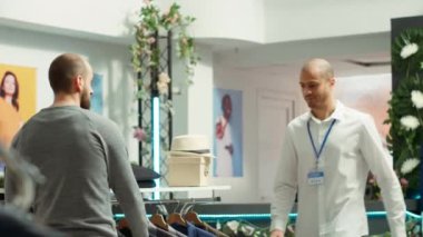 Perakende mağazası çalışanı genç bir müşteriye stil tavsiyesi, müşteri hizmetlerini iyileştirme ve yeni kaliteli giyim koleksiyonunu tavsiye etme konusunda yardımcı oluyor. Kişisel alışveriş deneyimi. Kamera A.