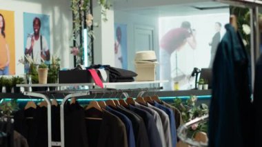 Modern boş bir perakende mağazasında gündelik gömleklerin karışımının sergilendiği şık ve şık kıyafetler. Müşterileri mevsimlik moda eğilimlerini keşfetmeye davet etmek.