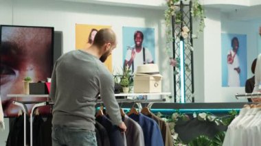 Ortadoğu çalışanı, müşteriye yeni ürün koleksiyonundan daha yüksek kumaş kalitesi ve potansiyel renk çeşitliliği sunarak seçmede yardımcı oluyor. Profesyonel perakende deneyimi. Kamera A.