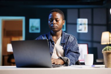 Çevrimiçi, araştırma ve projeler için modern teknolojiden yararlanan Afrikalı Amerikalı kız öğrenci. İnternette gezinmek ve e-postalara cevap vermek için dijital dizüstü bilgisayar kullanan ciddi bir serbest yazar.