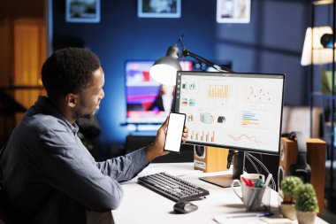 Tablette beyaz ekranlı analitik üzerinde çalışan yeni bir çalışan, boş izole edilmiş telif alanı şablonlu mobil aygıtı tutuyor. Strateji yöneticisi bilgisayardaki iş raporlarını inceler.