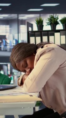 Dikey Video Siyah Şirketi CEO 'su çok çalıştıktan sonra masasında uyuyakalıyor ve yorgunluk ve baskıdan dolayı bunalmış hissediyor. İş kadını ofiste kestiriyor.