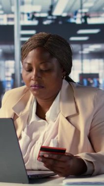 Dikey Video Afrikalı Amerikan CEO 'su kredi kartı numaralarını web sitesinden giriyor, ofis çalışma alanında online alışveriş yapıyor. Başarı öyküsü olan bir yönetmen elektronik alım ve ticaret yapıyor.