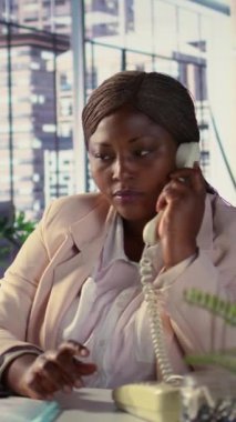 Dikey Video Afrikalı Amerikalı yönetmen finansal değerlendirme için sabit hattan arıyor. Kadın CEO kaynak tahsisi, bütçe planlaması ve son teslim tarihi yönetimi, karar verme konusunda görüştü