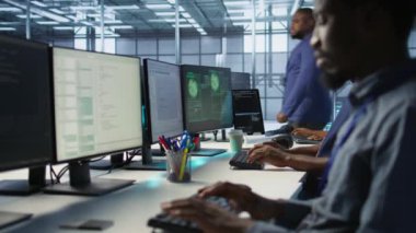 Veri merkezindeki bilgisayar ekranında kırmızı kritik hata gören programcı panikliyor. Sunucu merkezindeki Afrikalı Amerikalı adam hata aldıktan sonra spam klavye tuşlarına basıyor, kamera A