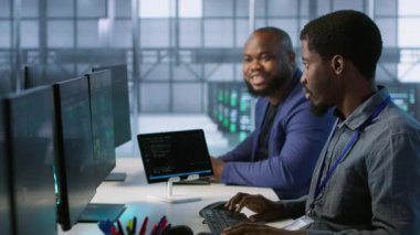 Veri merkezindeki neşeli iş arkadaşları yapay zeka öngörü bakım sistemlerini uyguluyorlar. Sunucu odası mühendisleri donanım arızalarını tespit etmek için yapay zeka kullanıyor. Kamera A