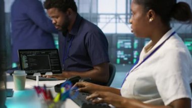 Bilgi işlem uzmanları beyin fırtınası yapıyor, şirket ağ altyapısını koruyor. Sunucu merkezi bilgisayar uzmanlarından oluşan bir ekip sohbet ediyor, optimal sistem performansını sağlıyorlar, kamera A