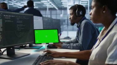 Bir grup programcı, veri işleme gereksinimleri için sunucu çiftliğinde çalışarak yeşil ekran tableti kullanıyor. Veri merkezinde krom anahtar aygıt üzerinde kodlama yapan takım arkadaşları, kamera A