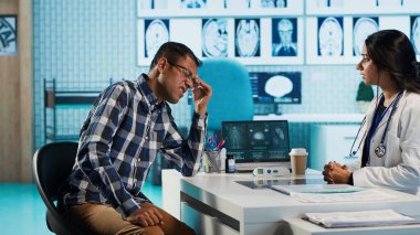 Hintli sıhhiyeci, sağlık için destek ve reçeteli ilaç önererek kontrol sırasında bir kutu takviye ve antibiyotik veriyor. Erkek uzman, doğru dozajda haplar öneriyor. Kamera A.