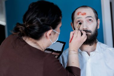 Sahne arkasındaki insanlar korku filmi çekimine hazırlanıyor. Aktör makyaj sanatçısıyla zombi rolüne hazırlanıyor. Gore Kozmetik, kan yaraları ve yara izleri uyguluyor.