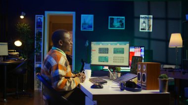 Afrika kökenli Amerikalı bir adam kişisel bilgisayar kullanarak muhasebe bilgisi hakkında konuşuyor. Çevrimiçi iletişim kuran ve aylık gelir dengesini inceleyen genç yetişkinler. Kamera A.