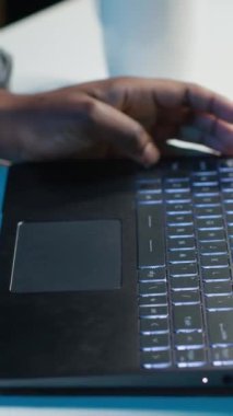 Evden çalışan dikey video telemetrisi, dizüstü bilgisayarda klavye yazma, belge yazma. Uzaktan çalışan klavyedeki tuşlara basıyor, iş ortaklarına e-posta gönderiyor, kamera A yakın plan