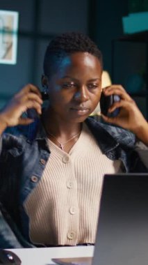 Dikey video çalışanı şirket projesi için verileri araştırırken müziğin keyfini çıkartıyor, bir gecede kişisel ev ofisinde görevler yapıyor. Dizüstü bilgisayarın önünde oturan ve kulaklık kullanan bir kadın.