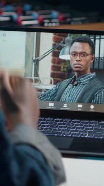 Dairesinde dikey videolu kadın terapistle video görüşmesi yapıyor, tavsiyelerini dinliyor. Lüks ve rahat bir evden psikoloğa danışmanlık yapan kişi önerilerini dinliyor. Kamera A.