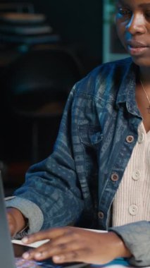 Evde çalışan dikey video girişimcisi, dizüstü bilgisayar kullanıyor ve kağıda notlar yazıyor. Kişisel apartman dairesindeki uzaktan çalışan, e-postaları cevaplayan ve not defterine önemli bilgiler yazan, kamera A