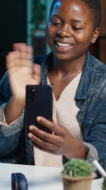 Dikey görüntülü kadın telefon alıyor, video konferansı sırasında en iyi arkadaşıyla akıllı telefon kullanarak konuşuyor. El sallayan kişi, cep telefonundaki selam veren arkadaş evdeki video görüşme oturumu, kamera