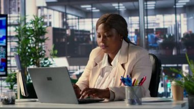 Ofisinde yetkilendirme ve hırsla yönetilen Afrikalı Amerikalı CEO, iş hedeflerine ulaşma ve şirket performansını dinamik bir şirket ortamında artırmaya odaklanıyor. Başarı hikayesi. Kamera A.