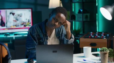 Oturma odasındaki yorgun kadın dizüstü bilgisayardaki birçok e-postaya cevap verdikten sonra sinirlendi. Aygıt klavyesine, kamera A 'ya yazarken kendini yorgun hisseden serbest çalışan biri.