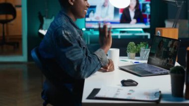 Gülümseyen çalışanların yöneticileri selamlaması, proje ilerlemesi hakkında geri bildirim almak için çevrimiçi video çağrısını kullanmaları. Neşeli işçi el sallıyor, telekonferans toplantısında iş arkadaşlarını selamlıyor, kamera A