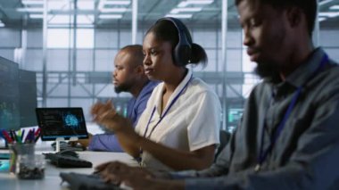 Mühendis veri merkezine geliyor, kulaklık takıyor, yapay zeka sistemlerini uyguluyor. Sunucu tarım uzmanı masada oturuyor, müzik dinliyor ve hataları önlemek için yapay zeka kullanıyor, kamera A