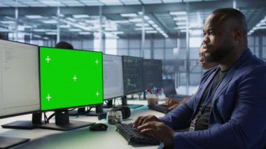 Afro-Amerikan veri merkezi yönetimi, şirket ağ altyapısını korumak için PC 'yi kullanıyor. Sunucu çiftliğinde çalışan bir adam yeşil ekran bilgisayarla optimal sistem performansı sağlıyor