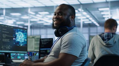 Yüksek teknoloji yapay zeka tesisinde çalışırken iş arkadaşı şakasına gülen mutlu bir mühendis. Yapay zeka veri merkezindeki meslektaşımın söylediği komik şakayla eğlenen neşeli adam, kamera A