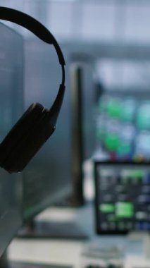 İşçilerin sunucu odasında bıraktığı kulaklıkların dikey videosu. Çalışanlar tarafından en az dinlenme süresini sağlamak için kullanılan bilgisayarlar. Performansı izlemek için kullanılan veri merkezi işyerindeki ekipman