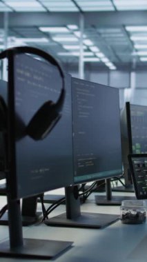 Boş veri merkezindeki dikey video elektronik cihazları donanım enerji tüketimini izliyor. Sunucu odasındaki ve el bilgisayarındaki potansiyel sistem hatalarını kontrol etmek için kullanılan masadaki bilgisayar monitörleri
