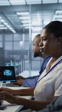 Dikey video veri merkezi mühendisi kulaklık takıyor şarkılardan keyif alıyor, şirket ağ altyapısını koruyor. Sunucu merkezindeki kadın müzik dinlerken optimal sistem performansını sağlarken, kamera
